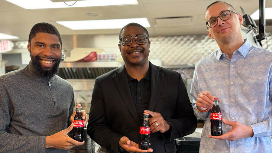 Three men holding cokes