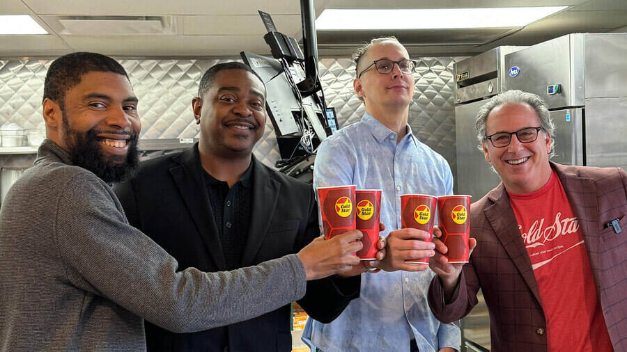 Four men smiling with fountain cokes