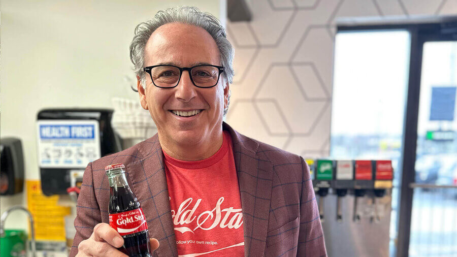 Man holding Classic coke bottle with goldstar on the label